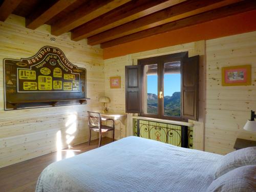 a bedroom with a bed and a desk and a window at Hotel rural reina Berta in Murillo de Gállego
