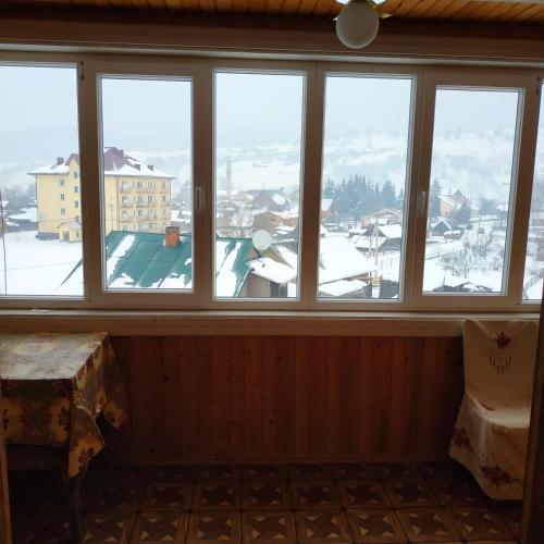 a room with windows with a view of a snow covered mountain at Подина in Vorokhta