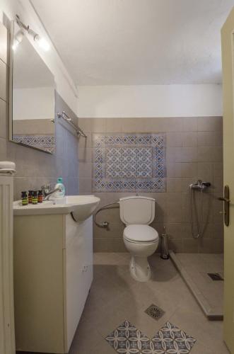 a bathroom with a toilet and a sink and a shower at Ev Zin Mouria in Leonidio