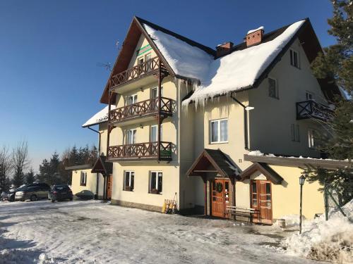 a large building with snow on the roof at Willa Karolina in Czorsztyn