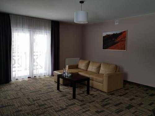 a living room with a couch and a coffee table at Centrum Promocji Leśnictwa w Mucznem in Lutowiska