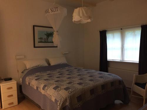 a bedroom with a bed with a sign on the wall at Landgoed De Heezeberg in Diever
