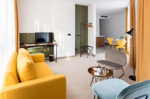 uma sala de estar com um sofá amarelo e uma mesa em Arche Hotel Lublin em Lublin