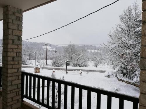 balcone con vista su un cortile coperto da neve. di Andromeda Hotel Limni Plastira a Koutsodímos