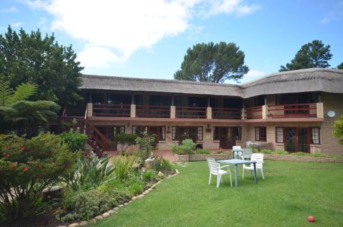 um edifício com uma mesa e cadeiras no pátio em Storms River Guest Lodge em Stormsrivier