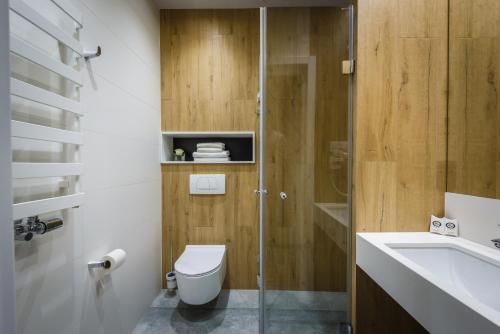 a bathroom with a shower and a toilet and a sink at Hotel Prezydent in Spała