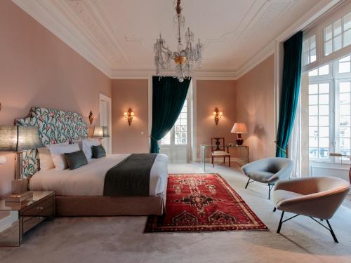 a bedroom with a large bed and a chandelier at Dear Lisbon - Valmor Palace in Lisbon