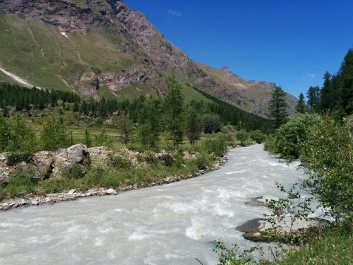 a river with a mountain in the background at Les Racines in Rhêmes-Notre-Dame