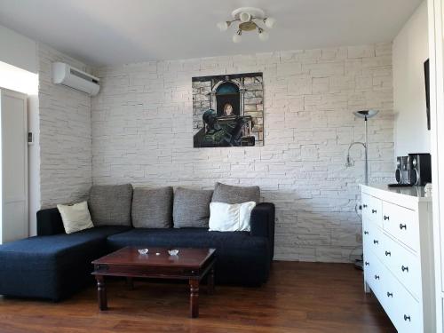 a living room with a blue couch and a brick wall at Apartment IVANA in Novalja
