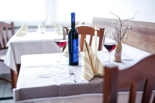a bottle of wine and two glasses on a table at Guest House Vila Moj Mir in Rateče