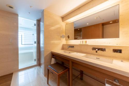 baño con lavabo grande y espejo en Hotel Associa Shin-Yokohama, en Yokohama