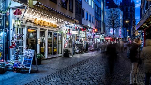 een stadsstraat 's nachts met mensen die over straat lopen bij Hotel am Museum Köln in Keulen