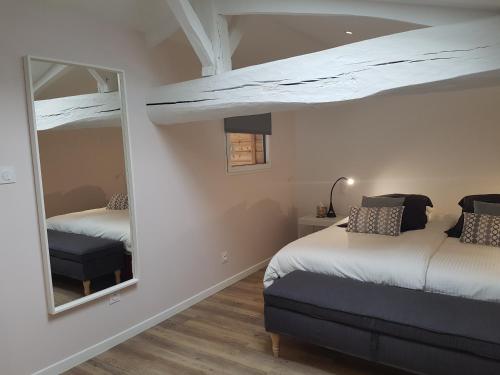 1 dormitorio con 2 camas y espejo en La Loge du Grand Cèdre, gîte de charme en Fontcouverte