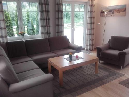 Una sala de estar con un sofá y una mesa de café. en Ferienhaus Berger, en Timmendorfer Strand