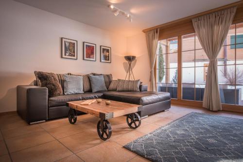 a living room with a leather couch and a coffee table at Luterbach in Lauterbrunnen