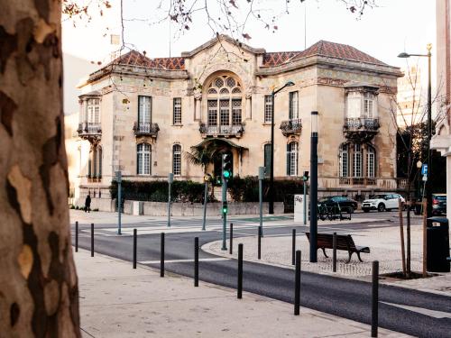 a building on a city street with a green traffic light at Dear Lisbon - Valmor Palace in Lisbon