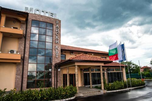 a hotel with two flags in front of it at SPA Kompleks Raiski Kat in Dimitrovgrad