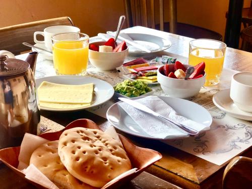 stół z talerzami jedzenia i szklanki soku pomarańczowego w obiekcie Hotel Vidal w mieście Pichilemu