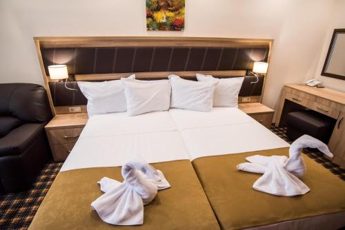 a hotel room with a bed with towels on it at SPA Kompleks Raiski Kat in Dimitrovgrad