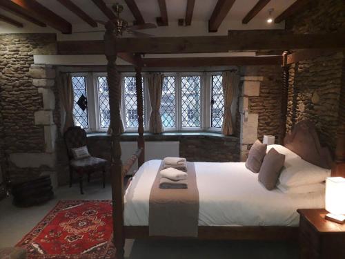 a bedroom with a large bed and a large window at Swan Inn Lechlade in Lechlade