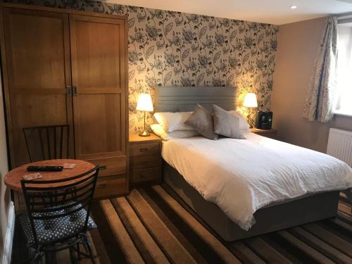 a bedroom with a bed and a table with a chair at Rokeby Inn in Newsham