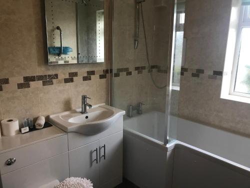 a bathroom with a sink and a tub and a mirror at Rokeby Inn in Newsham