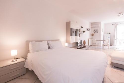 una camera bianca con un grande letto e una cucina di Cozy Sorrento Studio a Sorrento