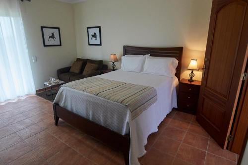 a bedroom with a large bed and a couch at Vivenda da Saudade B&B in Angra do Heroísmo