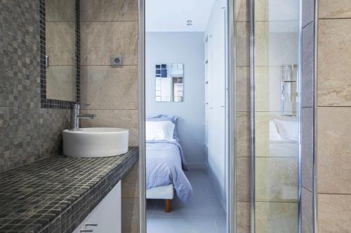 een badkamer met een wastafel en een slaapkamer bij Apartment Opéra / Galeries Lafayette in Parijs