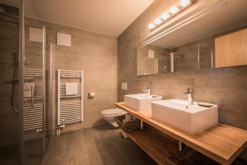 a bathroom with two sinks and a shower and a toilet at Luterbach in Lauterbrunnen