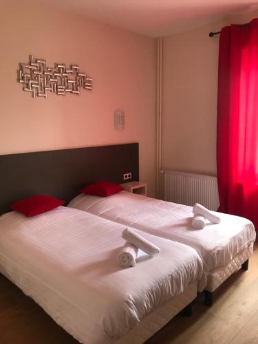 Logis Le Provençal في Euville: غرفة نوم بسريرين مع ستائر حمراء