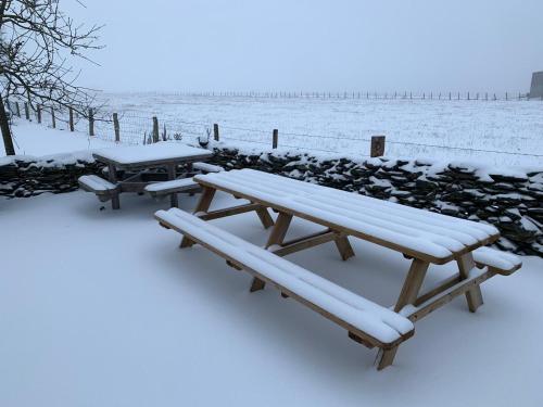 a picnic table and benches covered in snow at Ard'envie Bed&Breakfast in Cetturu