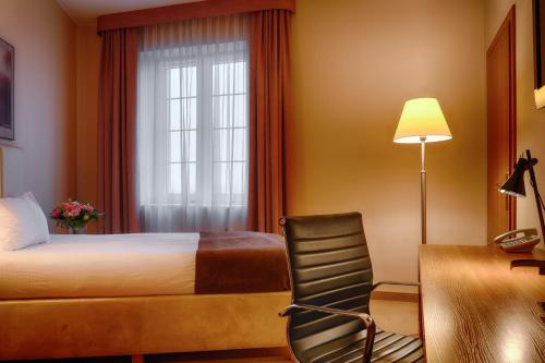 a hotel room with a bed and a window at Focus Hotel Szczecin in Szczecin