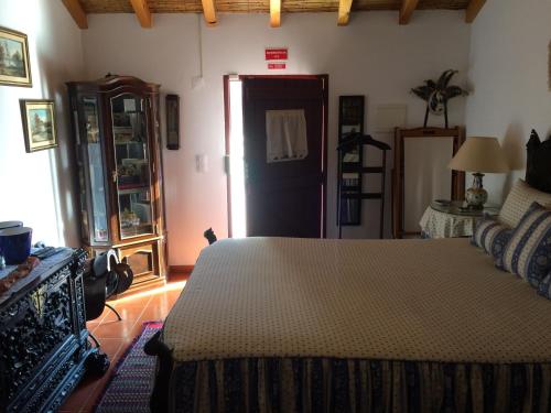 ein Schlafzimmer mit einem Bett in einem Zimmer mit einer Tür in der Unterkunft Quarto Monte Ninho das Perdizes in Cercal