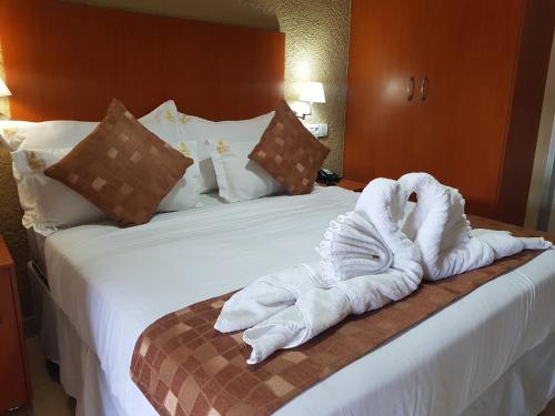 a hotel room with towels on a bed at Rekky Signature Guesthouse in Johannesburg