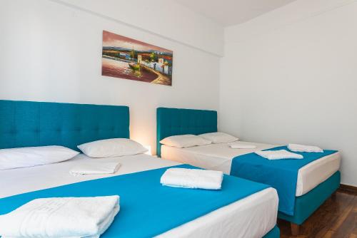 three beds in a room with blue and white at Super Paradise Apartments in Athens