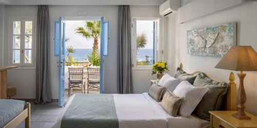 a bedroom with a bed and a view of the ocean at Ocean Bay Suites in Kamari