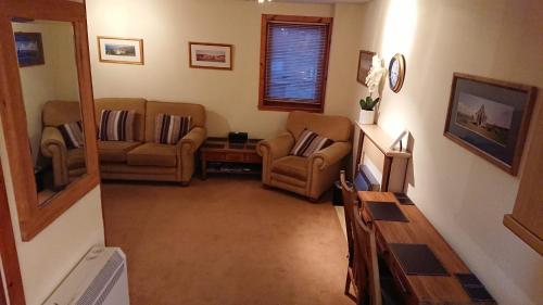 ein Wohnzimmer mit 2 Stühlen und einem Sofa in der Unterkunft Castleyards Apartment 12 in Kirkwall