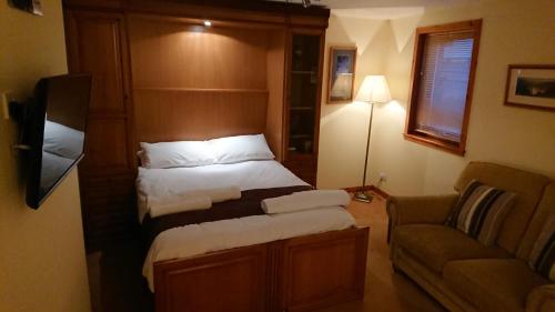ein Schlafzimmer mit einem Bett, einem Stuhl und einem Sofa in der Unterkunft Castleyards Apartment 12 in Kirkwall