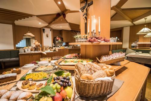 a buffet with many different types of food on a table at Vitaurina Royal Hotel in Molini di Tures