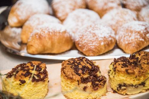 a bunch of pastries on a plate with powdered sugar at Vitaurina Royal Hotel in Molini di Tures