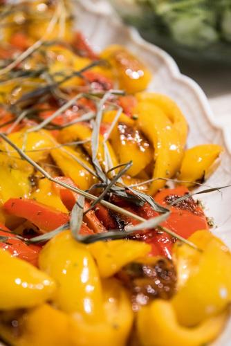 a plate of food with yellow and red peppers at Vitaurina Royal Hotel in Molini di Tures
