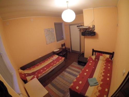 een kleine kamer met 2 bedden en een tafel bij Hostel Respect in Pančevo