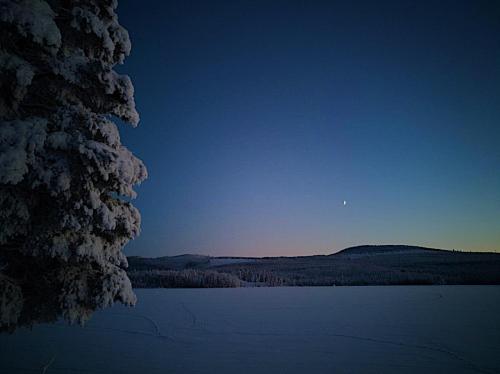 a view of a lake with the moon in the sky at Vildmarks Lodge in Ytterhogdal