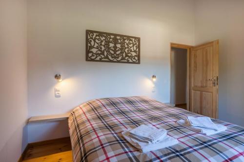 a bedroom with a bed with a plaid blanket at Village de Montmarsis in Gourdon-en-quercy