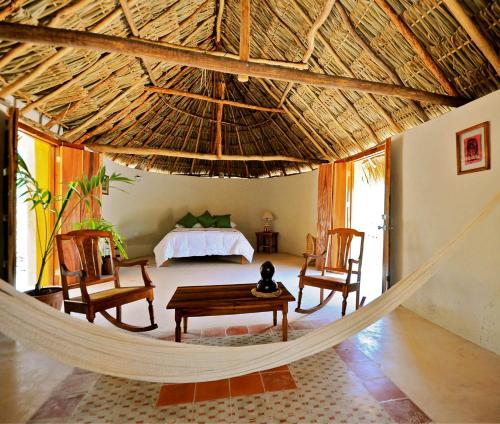 a hammock in a room with a bed at Hacienda San Francisco Tzacalha in Dzidzantún