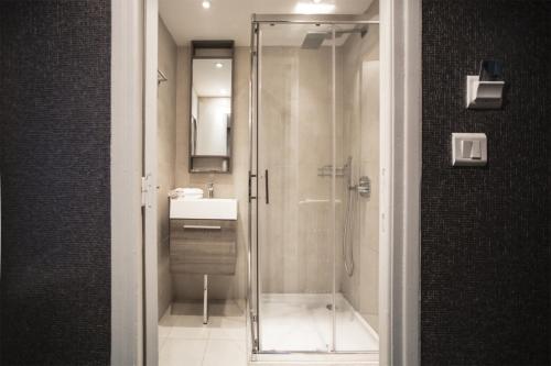 a bathroom with a shower and a sink at Hotel Schtak in Cannes