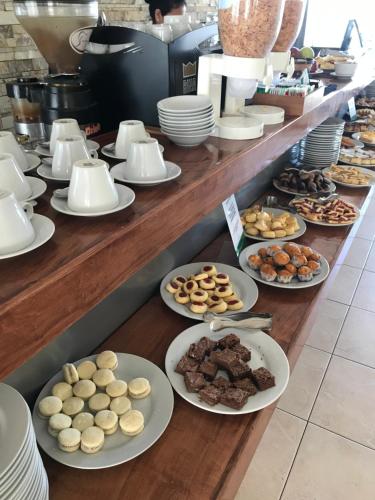 a buffet line with plates of pastries and desserts at Hostal del Sol in San Bernardo