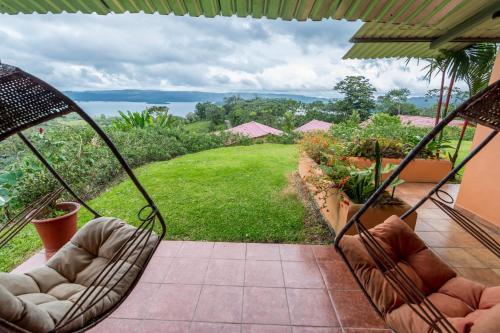 a porch with chairs and a view of a garden at Hotel Nepenthe B&B in El Castillo de La Fortuna