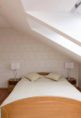 a bedroom with a large bed with two lamps on tables at Penzion Jollien in Námestovo